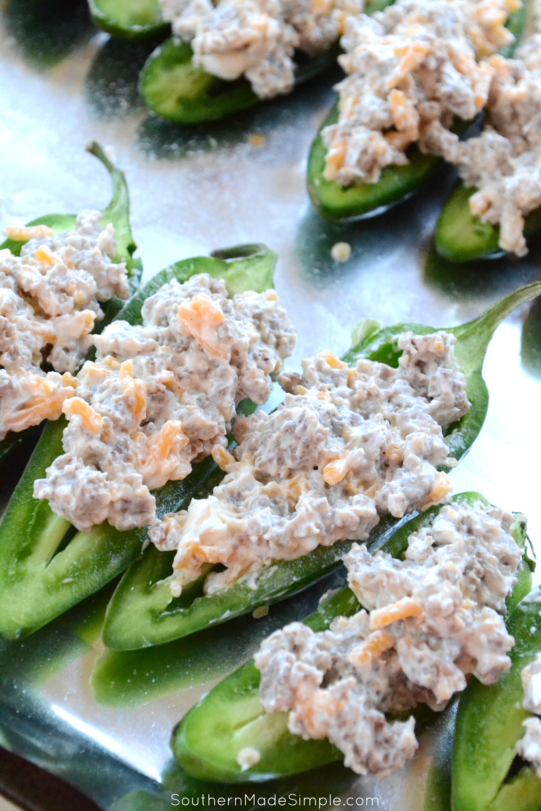 Easy sausage and cream cheese stuffed jalapeno peppers - a crazy easy appetizer that packs a delicious punch of heat!