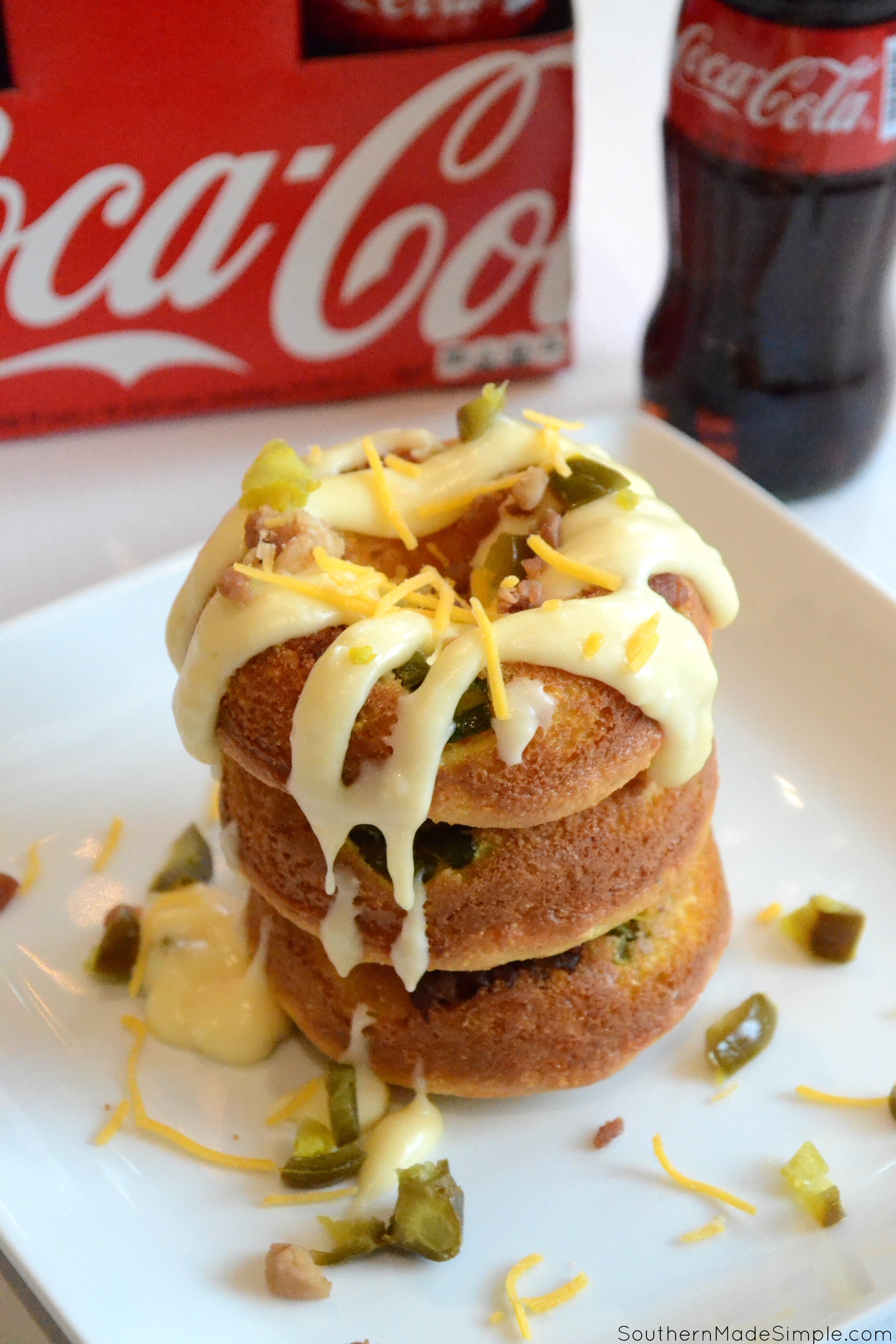 Serve up some spicy goodness during the big game with these savory Cheddar Bacon Jalapeno Doughnuts! They're a cheesy cornbread base with a spicy jalapeno cheese sauce that is in a league of it's own! Pair it with an ice cold Coca-Cola and you've got a winning hand! #ServeWithACoke #BowlGames #CollectiveBias